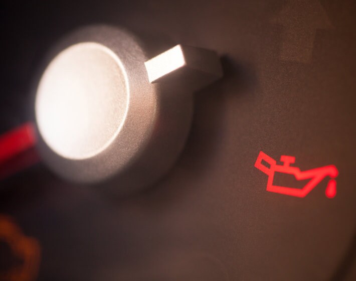 Red oil change icon on dashboard of car, indicating that an oil change is needed
