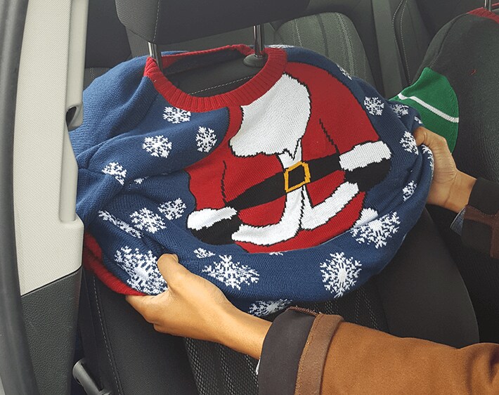 Pulling large ugly sweater over car seat
