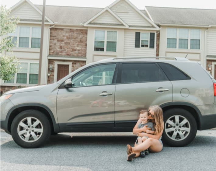 Mom and son in front of car