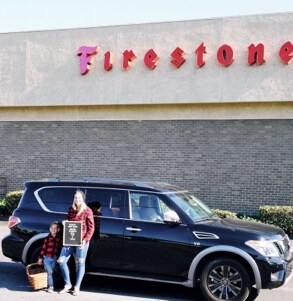 Family posing in front of a Firestone Complete Auto Care