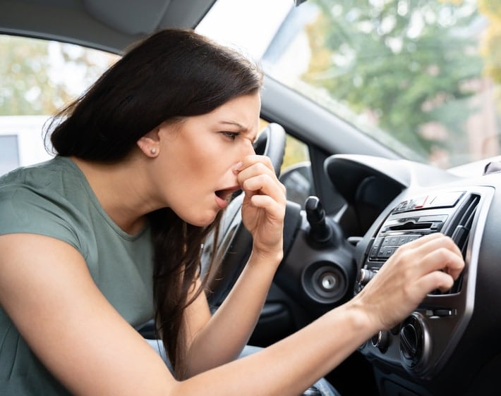 Woman smelling a bad smell coming from the A/C