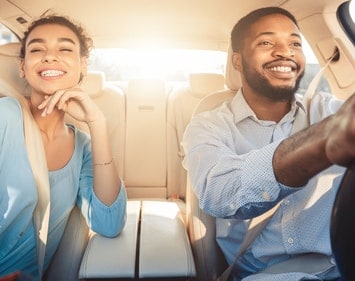 couple_smiling_while_driving_vehicle