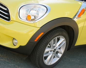 Front passenger side of a yellow vehicle with emphasis on standard tire.
