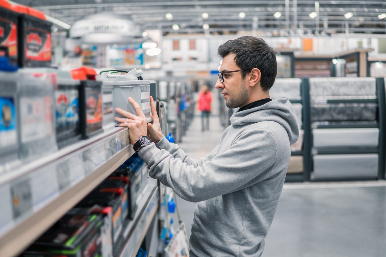 image of a man looking at a car battery on the shelf