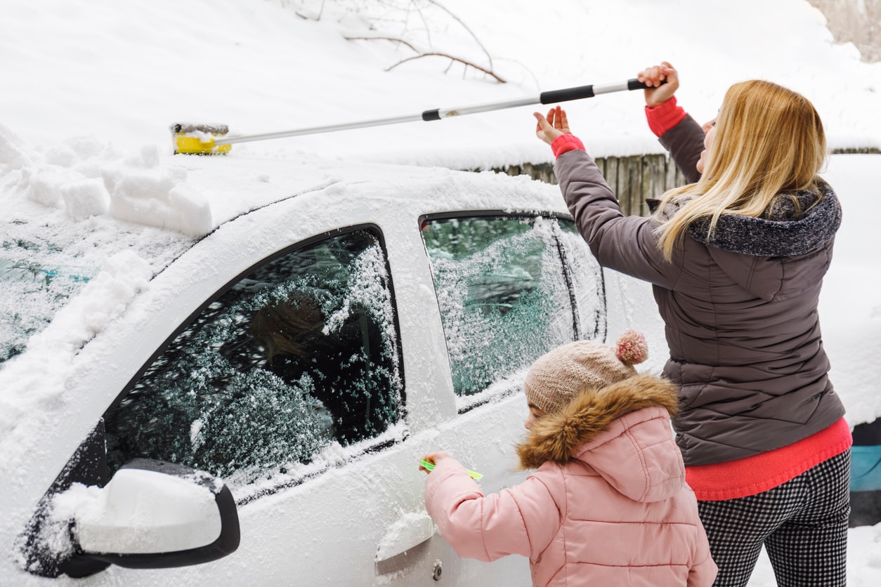 image of family removing snow from their car