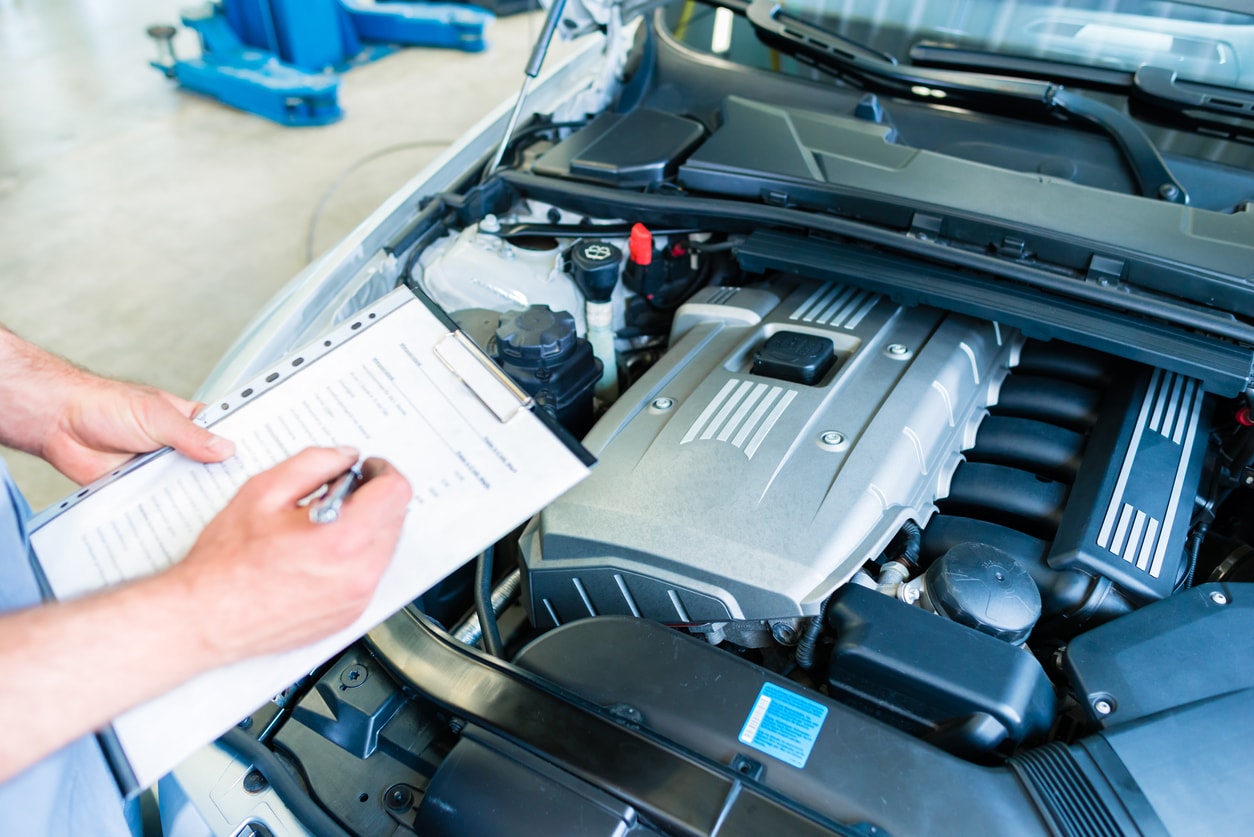 image of mechanic with a checklist in a car workshop