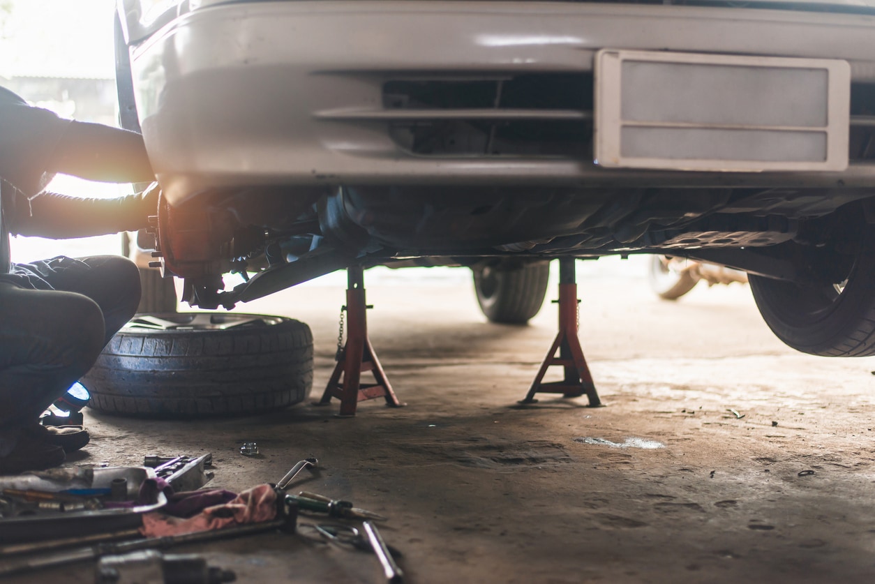 image of mechanic repairing suspension system of a car